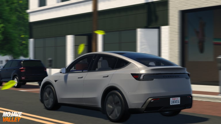 Silver electric crossover rolling past Mojave Valley storefronts